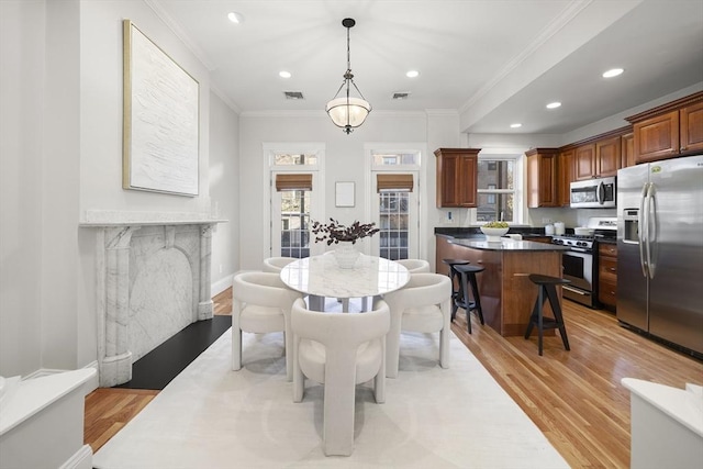 dining room featuring light hardwood / wood-style floors and crown molding