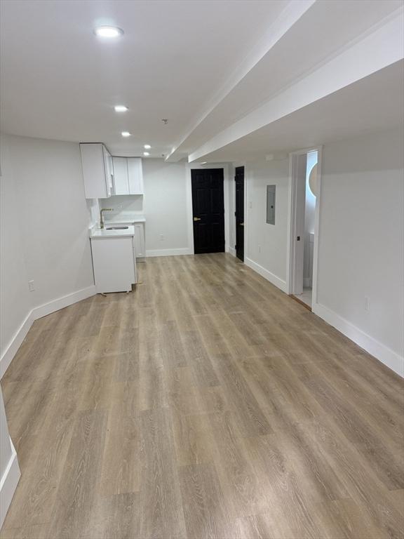 567 Park St Unit 1And B, Boston, MA 02124 - unfurnished living room featuring electric panel, baseboards, light wood-style flooring, a sink, and recessed lighting