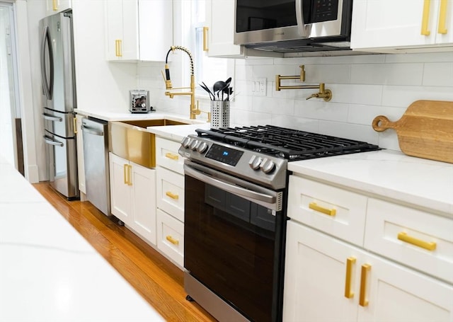 567 Park St Unit 1And B, Boston, MA 02124 - kitchen with appliances with stainless steel finishes, white cabinets, and backsplash