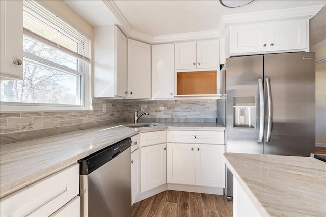 kitchen featuring tasteful backsplash, white cabinetry, sink, light stone counters, and stainless steel appliances