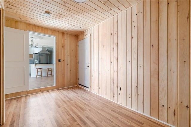 empty room with wood ceiling, hardwood / wood-style flooring, and wooden walls