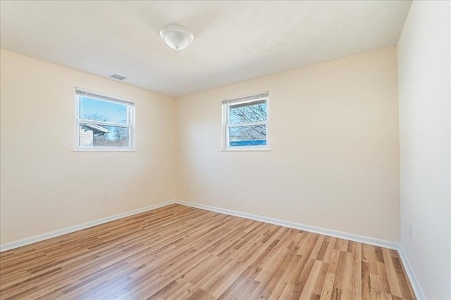 empty room with a healthy amount of sunlight and light hardwood / wood-style flooring