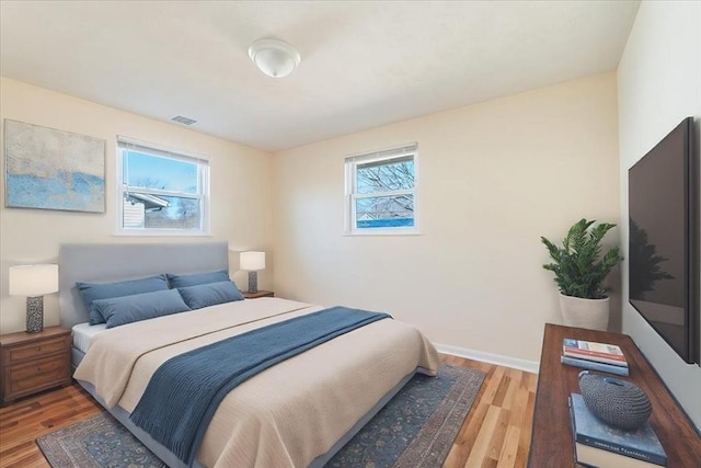 bedroom featuring multiple windows and hardwood / wood-style floors