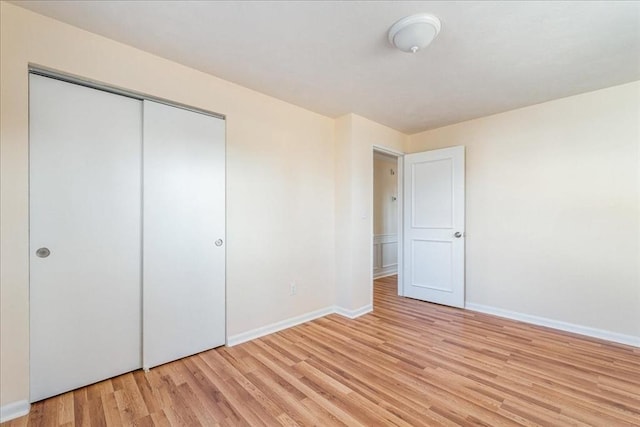 unfurnished bedroom with a closet and light hardwood / wood-style flooring