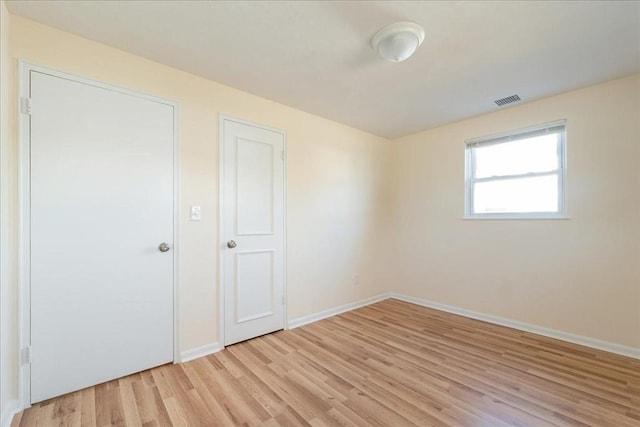 empty room with light hardwood / wood-style flooring