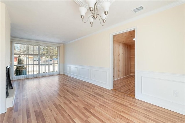 unfurnished dining area featuring crown molding, a chandelier, and light hardwood / wood-style flooring