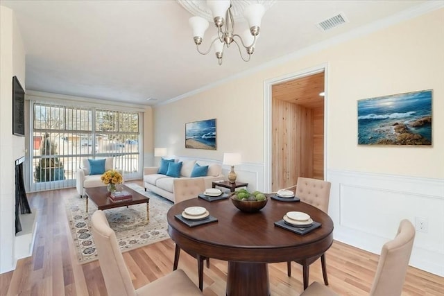 living room with crown molding, hardwood / wood-style floors, and an inviting chandelier