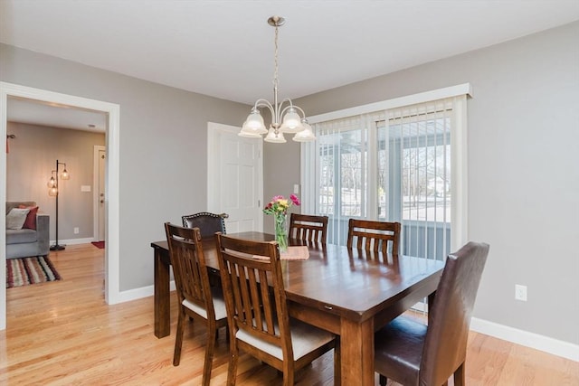 dining area featuring a notable chandelier and light wood-type flooring