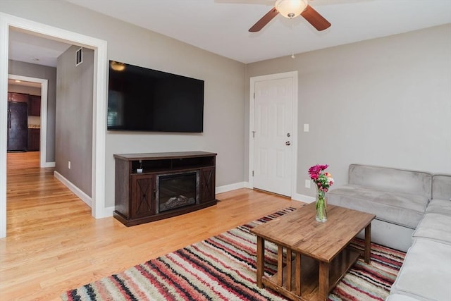 living room with hardwood / wood-style flooring and ceiling fan