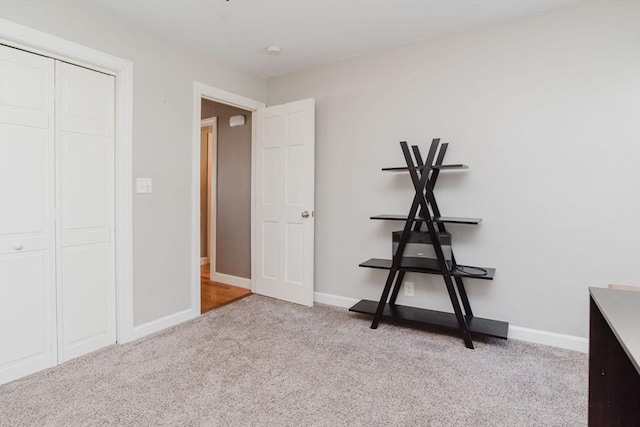 unfurnished bedroom with light carpet and a closet