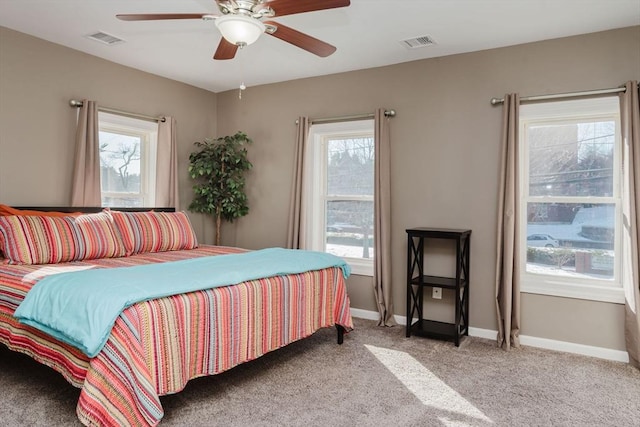 bedroom featuring multiple windows, light carpet, and ceiling fan