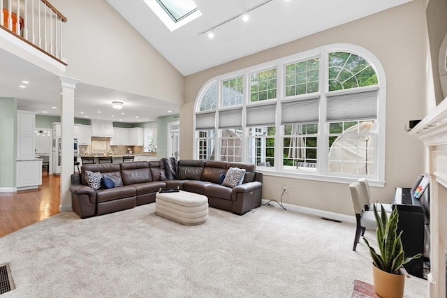 3 Anders Way, Acton, MA 01720 - living area featuring track lighting, light carpet, baseboards, a skylight, and high vaulted ceiling