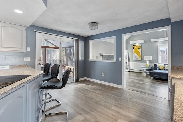 office area with a baseboard heating unit and light hardwood / wood-style flooring