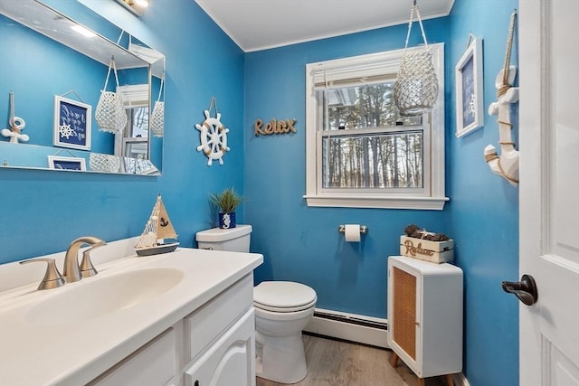 bathroom with toilet, vanity, baseboard heating, and wood-type flooring