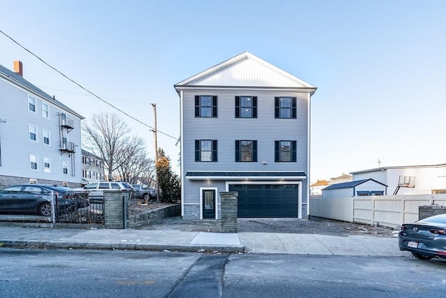 view of front of property featuring a garage, driveway, and fence