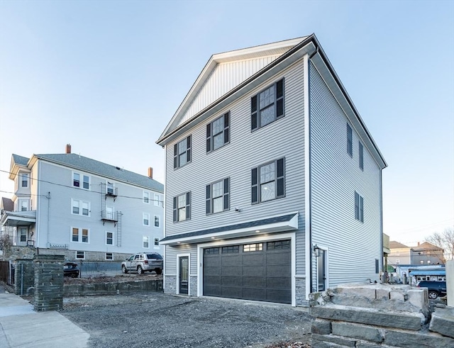 view of front of home featuring board and batten siding, stone siding, driveway, and a garage