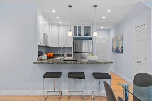 31-33 New Ocean St, Swampscott, MA 01907 - kitchen with freestanding refrigerator, a peninsula, light wood-type flooring, white cabinetry, and recessed lighting