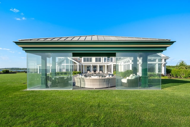 rear view of property with a yard, an outdoor hangout area, and a patio