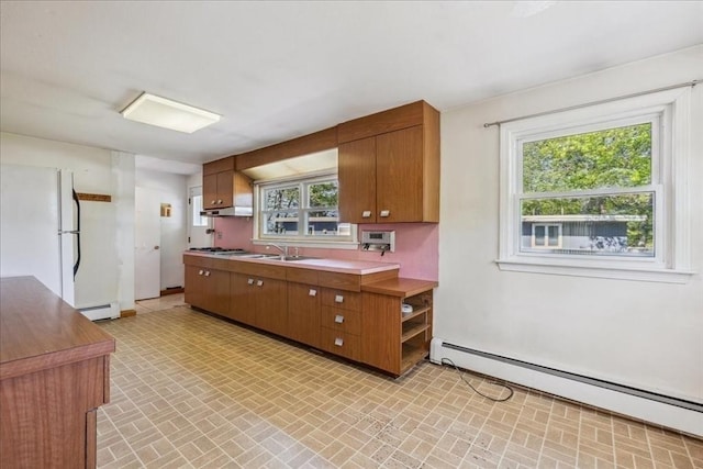 7 Wilbur Ct, Saugus, MA 01906 - kitchen with a baseboard heating unit, brown cabinets, and brick patterned flooring