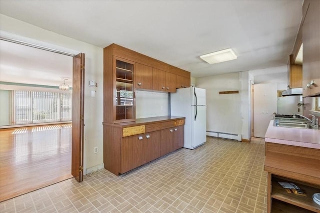 7 Wilbur Ct, Saugus, MA 01906 - kitchen with freestanding refrigerator, a baseboard radiator, brick patterned floors, and brown cabinets