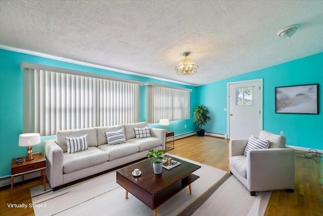7 Wilbur Ct, Saugus, MA 01906 - living room with a textured ceiling, wood finished floors, a baseboard heating unit, a chandelier, and baseboards