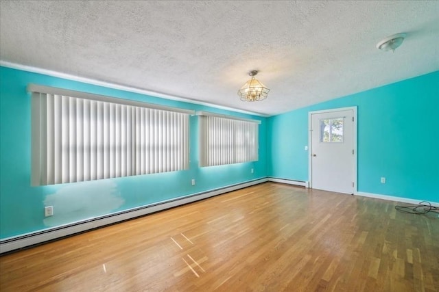 7 Wilbur Ct, Saugus, MA 01906 - spare room featuring a textured ceiling, a chandelier, wood finished floors, baseboards, and baseboard heating