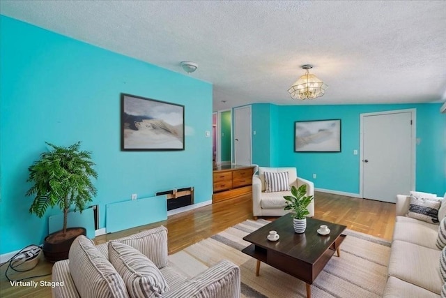 7 Wilbur Ct, Saugus, MA 01906 - living area with a textured ceiling, a chandelier, wood finished floors, and baseboards