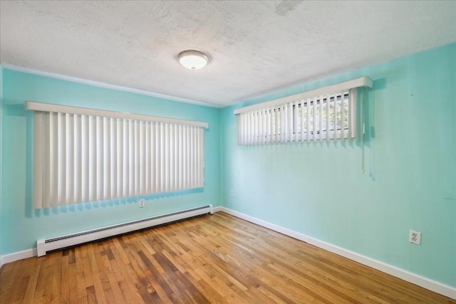 7 Wilbur Ct, Saugus, MA 01906 - spare room with a baseboard heating unit, baseboards, wood finished floors, and a textured ceiling