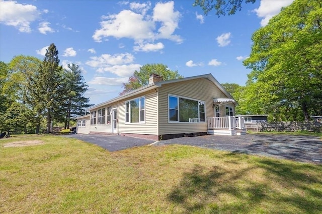 7 Wilbur Ct, Saugus, MA 01906 - rear view of house with a lawn and a chimney