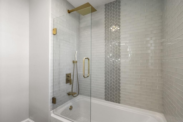 full bathroom featuring baseboards and shower / bath combination with glass door