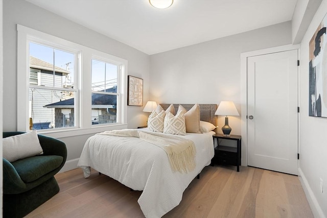 bedroom with light wood-style floors and baseboards