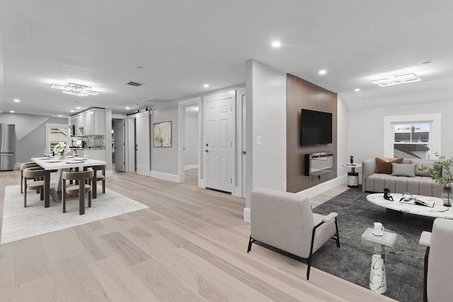 living room with recessed lighting, baseboards, visible vents, and light wood-type flooring
