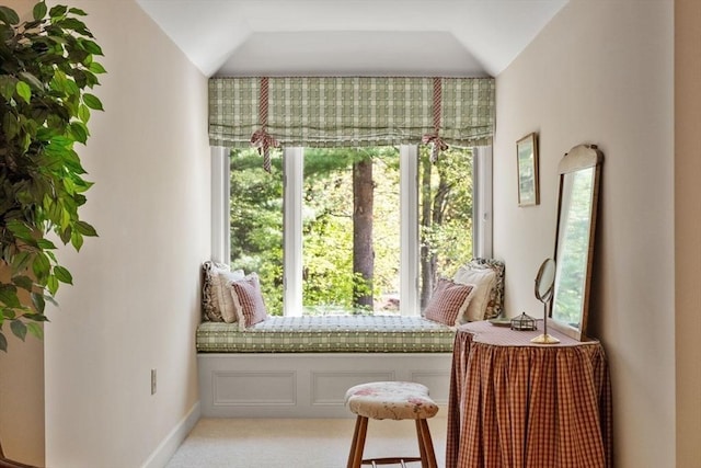 sitting room with plenty of natural light, vaulted ceiling, light carpet, and baseboards