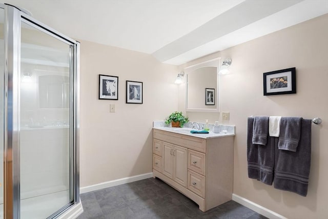 full bath featuring a stall shower, vanity, and baseboards