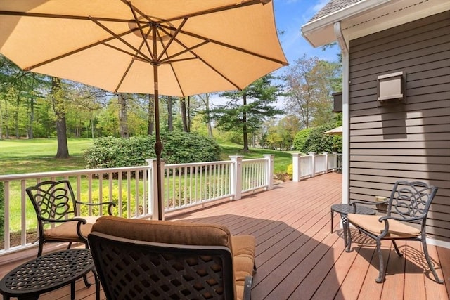 deck with a yard and view of wooded area