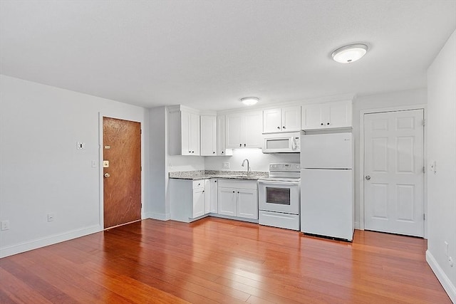 kitchen featuring light hardwood / wood-style flooring, white cabinets, white appliances, and sink