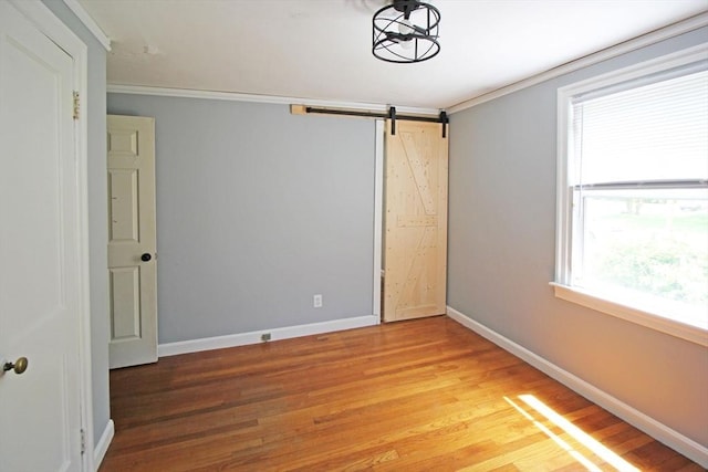 1 Stratford Rd, Holyoke, MA 01040 - empty room featuring light wood-type flooring, baseboards, crown molding, and a barn door