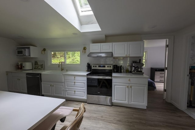 400 Loomis St, Westfield, MA 01085 - kitchen with stainless steel appliances, a sink, under cabinet range hood, a skylight, and white cabinets