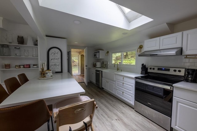 400 Loomis St, Westfield, MA 01085 - kitchen with appliances with stainless steel finishes, under cabinet range hood, a skylight, light countertops, and light wood-type flooring