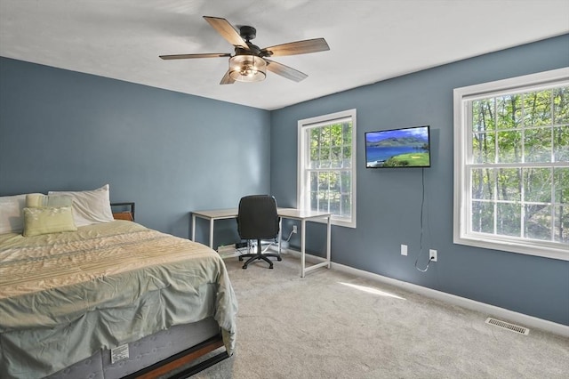 carpeted bedroom featuring baseboards, a ceiling fan, and visible vents