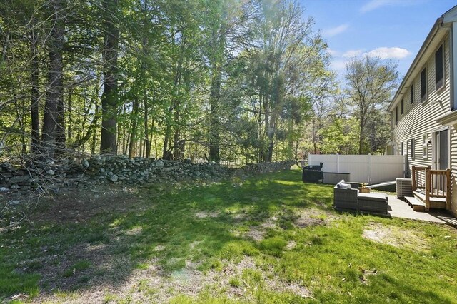 view of yard with cooling unit, outdoor lounge area, and fence