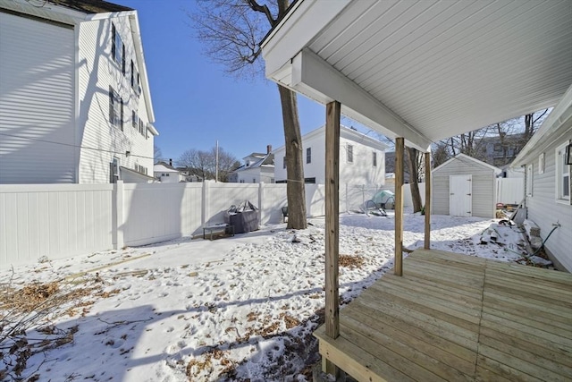 snow covered deck with a storage shed