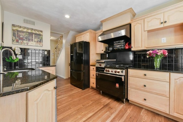 43 Endicott St Unit 43, Salem, MA 01970 - kitchen with black refrigerator with ice dispenser, light brown cabinets, wall chimney range hood, gas range oven, and light wood-style floors