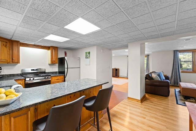 111 Esta Rd, Plymouth, MA 02360 - kitchen featuring stainless steel range with gas stovetop, freestanding refrigerator, brown cabinets, a peninsula, and open floor plan
