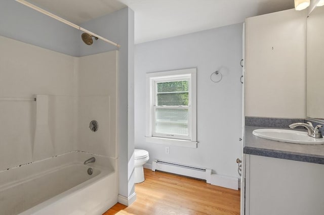 270 Main St, Oxford, MA 01540 - bathroom featuring a baseboard radiator, toilet, vanity, wood finished floors, and washtub / shower combination