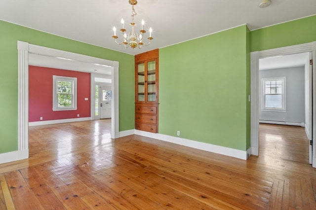270 Main St, Oxford, MA 01540 - empty room with a baseboard radiator, a chandelier, baseboards, and wood-type flooring