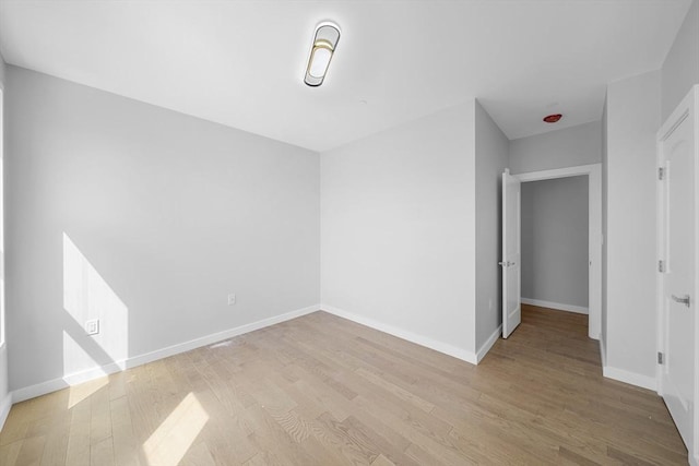 unfurnished room with baseboards and light wood finished floors