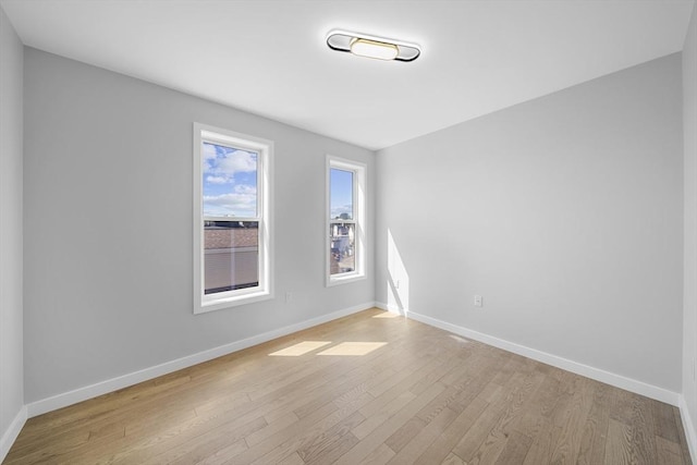 unfurnished room featuring light wood-type flooring and baseboards