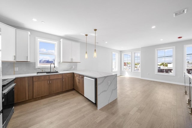 kitchen featuring a peninsula, range with electric cooktop, visible vents, light wood-style floors, and dishwasher