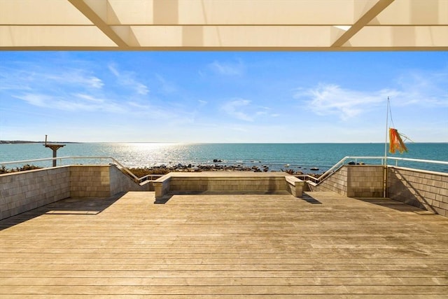 dock area with a water view and a beach view